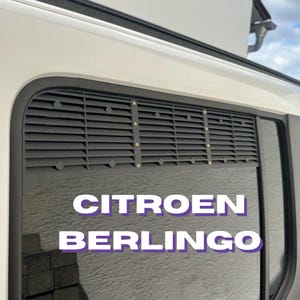 Peut inclure: Grille d'aération noire à lattes horizontales et rivets dorés, montée sur un véhicule blanc. Le texte "CITROEN BERLINGO" est affiché en blanc et violet sur la vitre.