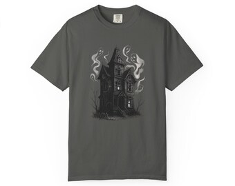 Op de afbeelding: Donkergrijs t-shirt met een zwart-wit illustratie van een spookhuis en geesten. Het griezelige ontwerp toont een gedetailleerd herenhuis met rook en spookachtige figuren, ideaal voor Halloween.
