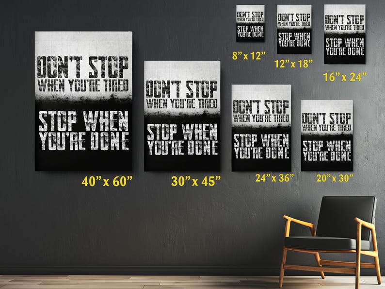 a collection of motivational posters with the text "DON'T STOP WHEN YOU'RE TIRED" displayed on them. The posters vary in size, with some being larger than others, and are arranged on a wall. There is also a chair in the background, suggesting a space for relaxation or contemplation.