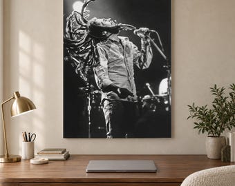 May include: A black and white photographic wall art print depicting a musician with long dreadlocks performing on stage. The individual is captured mid-motion, singing into a microphone while wearing a button-down shirt, with stage lights visible.