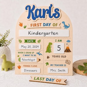 Könnte beinhalten: Ein bogenförmiges Holzschild mit der Aufschrift Karl's First Day of Kindergarten, verziert mit Dinosaurier-Illustrationen, Datum 20. Mai 2024, Alter 5, Berufswunsch Paläontologe, Lehrerin Mrs. Smith und einem separaten Last Day of Holzschild.