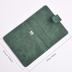 May include: Green leather wallet, open to reveal card slots and a SIM card holder. The wallet is 9 inches long and 5.9 inches wide. It has a snap closure and a small RFID tag.