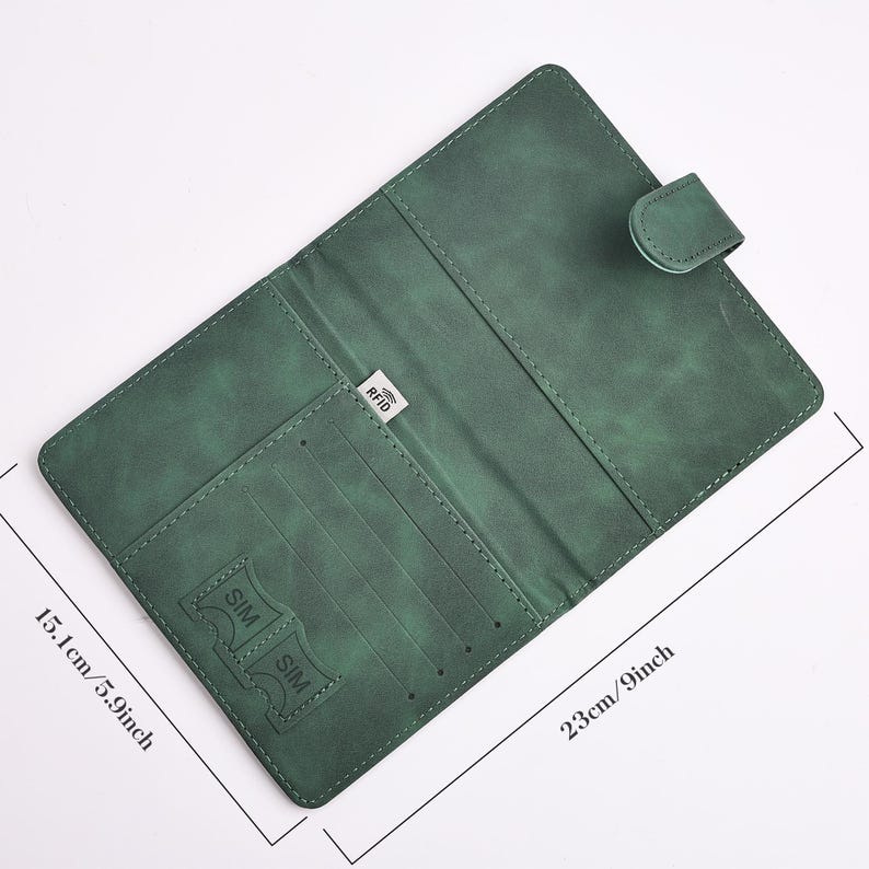 May include: Green leather wallet, open to reveal card slots and a SIM card holder. The wallet is 9 inches long and 5.9 inches wide. It has a snap closure and a small RFID tag.
