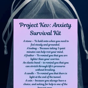 Może przedstawiać: Biały woreczek z organzy zawiązany wstążką, zawierający kartę z napisem "Project Kev: Anxiety Survival Kit". Karta zawiera przedmioty takie jak kamień, torebka herbaty, pióro, gumka recepturka, świeca, moneta i serca miłości.