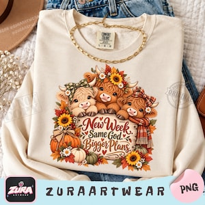 Pode incluir: Uma camisola de gola redonda cor de creme com um gráfico de três vacas Highland adornadas com flores de outono e acessórios aos quadrados. O centro inclui uma placa de madeira com o texto New Week Same God Bigger Plans.