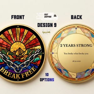 May include: A gold-colored coin with a stained-glass design. The front features a sunrise over mountains with the words "BREAK FREE" and a chain. The back says "2 YEARS STRONG" and "You broke what broke you".