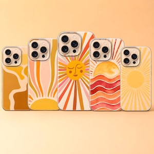 May include: A collection of five phone cases with retro-style sun designs. The cases feature various color schemes, including orange, yellow, and pink, with sunburst and wavy patterns. Each case has a clear border and a camera cutout.