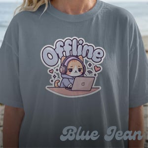 Peut inclure: T-shirt bleu jean avec le mot "Offline" au-dessus d'un chat de dessin animé portant un casque et utilisant un ordinateur portable. L'illustration du chat est entourée de cœurs et de symboles sans fil.
