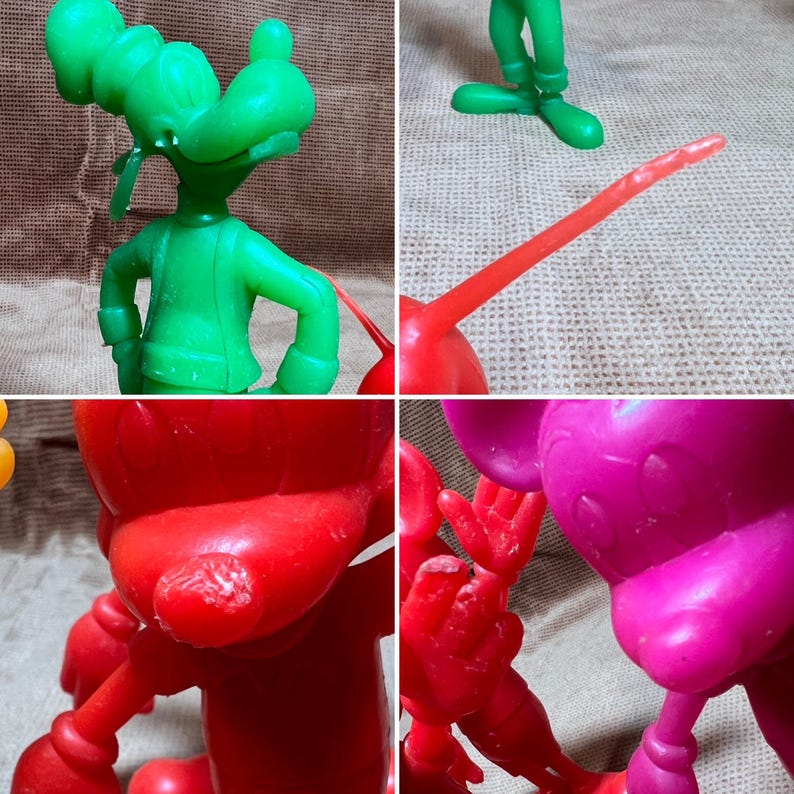 May include: A set of four vintage plastic cartoon character figurines. The figurines are green, red, pink, and yellow. The figurines are of Mickey Mouse, Donald Duck, Goofy, and Pluto.