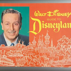 Puede incluir: Una gu&iacute;a vintage naranja y amarilla para Disneyland con un retrato de Walt Disney e ilustraciones de las atracciones del parque. El texto dice "Walt Disney's Guide to Disneyland".