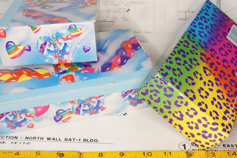 May include: Three rectangular boxes with colorful designs. Two boxes feature a light blue background with white unicorns, rainbow hearts, and red hearts. The third box has a vibrant rainbow gradient background with a purple leopard print pattern.