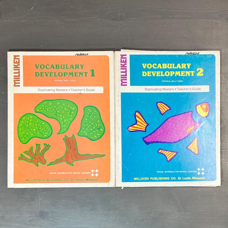 May include: Two educational workbooks titled "Vocabulary Development 1" and "Vocabulary Development 2" by Patricia Kelly Toch. The books are orange and blue with illustrations of a tree and a fish.