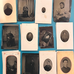 May include: A collection of 12 vintage oval-shaped photographs in black and white. The photos are mounted on white and cream cardstock with ornate borders. Some of the photos have handwritten text on them, including "Mrs. Smith" and "Mark".