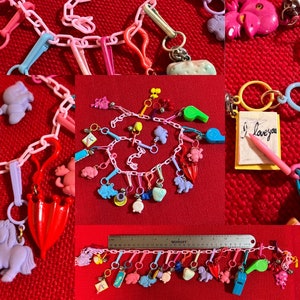 May include: A pink plastic chain necklace with colorful charms, including a red umbrella, a whistle, a unicorn, a cat, a strawberry, and a note that says "I love you".