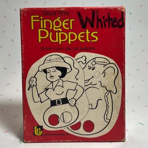 May include: A vintage red box of "Circus Time Finger Puppets" with a cartoon illustration of a woman and an elephant. The box has the text "16 full-color, die cut puppets". The box is slightly worn.