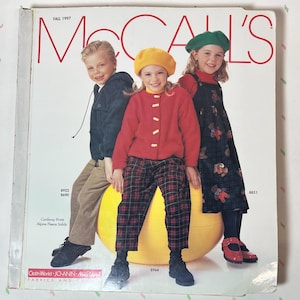 May include: McCall's Fall 1997 catalog cover featuring three children. The cover has the McCall's logo in red. The children are wearing fall clothing, including a red jacket, plaid pants, and a green beret. The catalog includes the numbers 8922, 8690, 8964, and 8851.