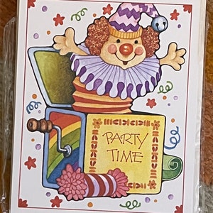 May include: A colorful card with a cartoon clown popping out of a box with the words "Party Time" on it. The clown is wearing a purple and white striped hat and a purple and white ruffled collar. The box is decorated with a rainbow and a pink and white striped candy.