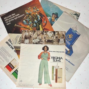 May include: A collection of vintage cigarette advertisements. The ads feature text and images, including a woman in a green jumpsuit, a blue and gold cigarette pack, and the text "VIRGINIA SLIMS."