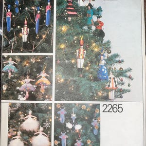 May include: A Vogue Patterns 2265 sewing pattern envelope featuring illustrations of various handmade Christmas tree ornaments, including nutcracker figures, dancers in elaborate costumes, and small animal-shaped decorations.