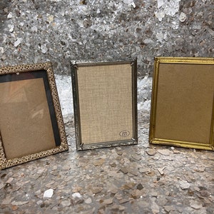 a trio of gold metal frames