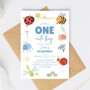 Könnte beinhalten: Eine weiße Einladungskarte mit dem Text "our boy is ONE cute bug" und Illustrationen von Käfern und Blumen. Die Karte ist für einen 1. Geburtstag und enthält Veranstaltungsdetails. Die Karte liegt auf einem braunen Umschlag.