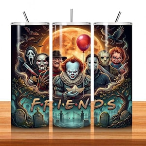 May include: A cylindrical tumbler with a straw featuring a horror-themed graphic print. The design displays iconic movie villains, a red balloon, a full moon, and a graveyard scene. The word FRIENDS is written in a stylized font at the bottom.