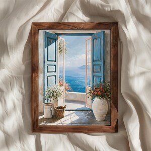 May include: A framed wall art print depicting an open window with blue shutters overlooking a calm blue sea. The scene includes white and red flowers in ceramic pots and a small woven basket on a stone balcony under a bright sky.