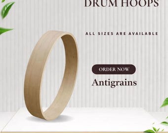 May include: A light-colored wooden drum hoop, displayed on a white surface. The text "WOODEN DRUM HOOPS" is at the top, with "ALL SIZES ARE AVAILABLE" below. A button reads "ORDER NOW" with the name "Antigrains" below.