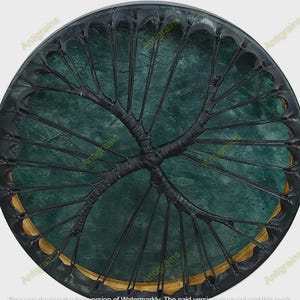 Può includere: Un oggetto decorativo rotondo, verde scuro, con un design nero a raggi che si irradia dal centro. Il bordo presenta un accento dorato. L'oggetto ha un aspetto strutturato.