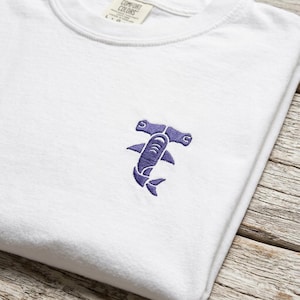 Maglietta dai colori morbidi e confortevoli con ricamo di uno squalo martello.