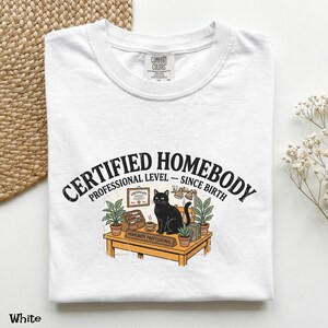 Camiseta "Certified Homebody" (Homem Caseiro Certificado), Camiseta "Profissional Desde o Nascimento", Camiseta Divertida com Gato Preto para Quem Ama Casa, Camiseta para Amantes de Gatos Introvertidos, Camiseta Divertida para Ficar em Casa