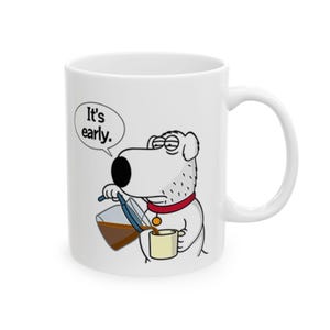 May include: White ceramic mug featuring a cartoon dog pouring coffee. The dog wears a red collar and has a speech bubble that says "It's early."