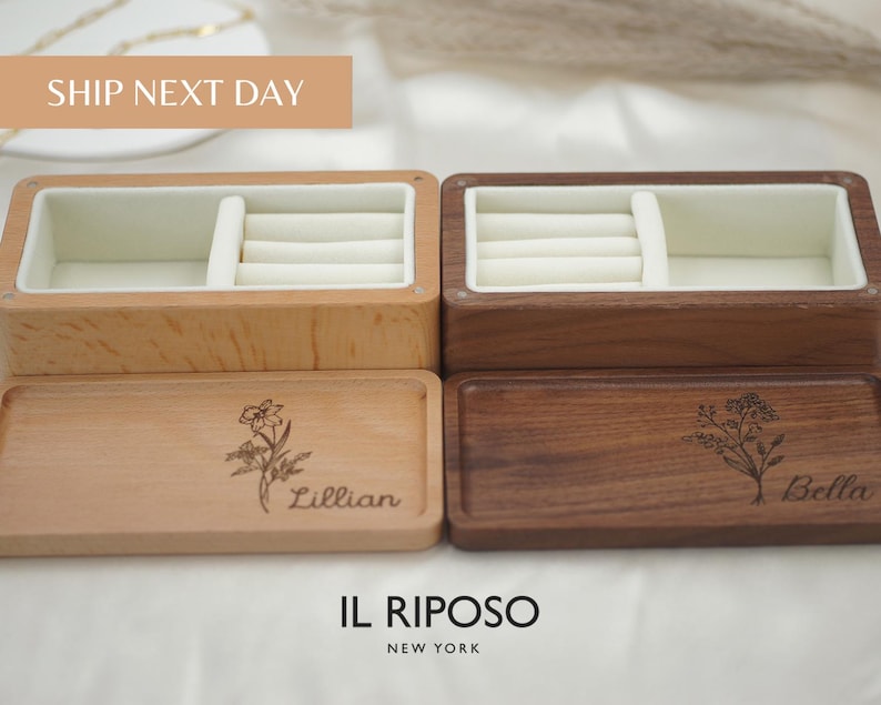 Puede incluir: Dos joyeros de madera, uno claro y otro oscuro, con interiores color crema. Las tapas est&aacute;n grabadas con dise&ntilde;os florales y nombres. El texto "IL RIPOSO NEW YORK" est&aacute; en la parte inferior.