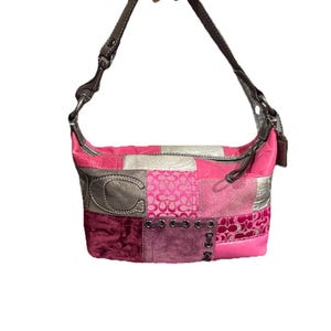May include: A patchwork shoulder bag in shades of pink, silver, and burgundy. The bag features a variety of textures and patterns, including velvet, suede, and a logo. It has a brown leather strap and silver hardware.