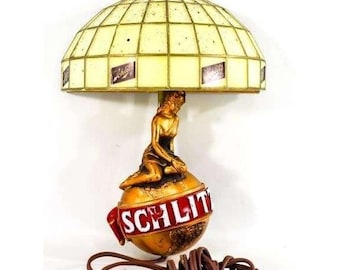 Applique da parete vintage del 1971 con la scritta Schlitz alla spina e l'immagine di una donna su un globo.