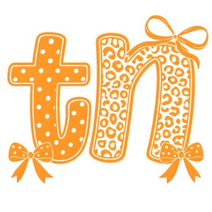 Puede incluir: Gráfico naranja con las letras "tn". La letra "t" es naranja con lunares blancos, y la letra "n" tiene un estampado de leopardo. Hay lazos naranjas en la parte superior e inferior de la "n" y en la parte inferior de la "t".