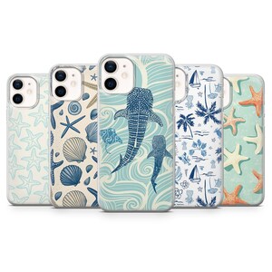 Peut inclure: Cinq coques de téléphone avec des motifs sur le thème de l'océan. Les motifs comprennent des étoiles de mer, des coquillages, des baleines, des palmiers et des voiliers dans des tons de bleu, beige et blanc. Les coques sont conçues pour un smartphone.