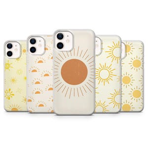 May include: A collection of five phone cases with various sun designs. The cases feature a clear border and a cream-colored background. The sun designs include a large orange sun with rays, and repeating patterns of yellow suns and sunbursts.
