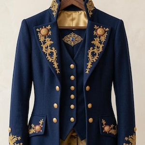 Pode incluir: Um casaco comprido azul-marinho com bordados dourados e colete a condizer. O casaco apresenta uma gola alta, bot&otilde;es dourados e detalhes intrincados em fio dourado nas lapelas, punhos e bainha. Um forro de cetim dourado &eacute; vis&iacute;vel no interior.