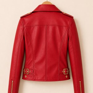 May include: A vibrant red leather jacket with a classic biker style. Features include a notched collar, shoulder epaulets, and gold-toned zippers and hardware. The jacket has a tailored fit and decorative diamond-shaped accents on the waist belt.