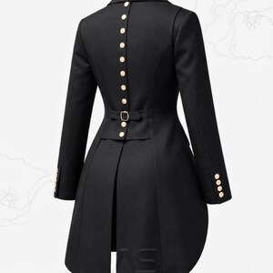 May include: A black long-sleeved jacket featuring a high collar and a row of gold-toned buttons running vertically down the centre back. The garment includes a waist-cinching strap with a gold buckle and four gold buttons on each sleeve cuff.