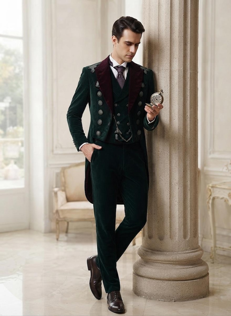 May include: A dark green velvet tailcoat suit featuring a deep burgundy velvet lapel, a matching waistcoat with silver-toned buttons, and dark green velvet trousers. The ensemble includes a white collared shirt, a dark tie, and brown leather shoes.