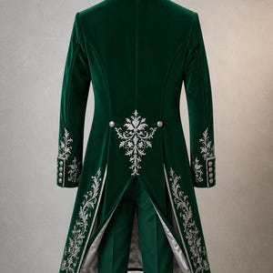 Puede incluir: Una levita de terciopelo verde oscuro con intrincados bordados plateados en el cuello, los pu&ntilde;os y los paneles traseros. El abrigo incluye botones plateados en la cintura y un dise&ntilde;o de espalda abierta, junto a un pantal&oacute;n verde a juego.