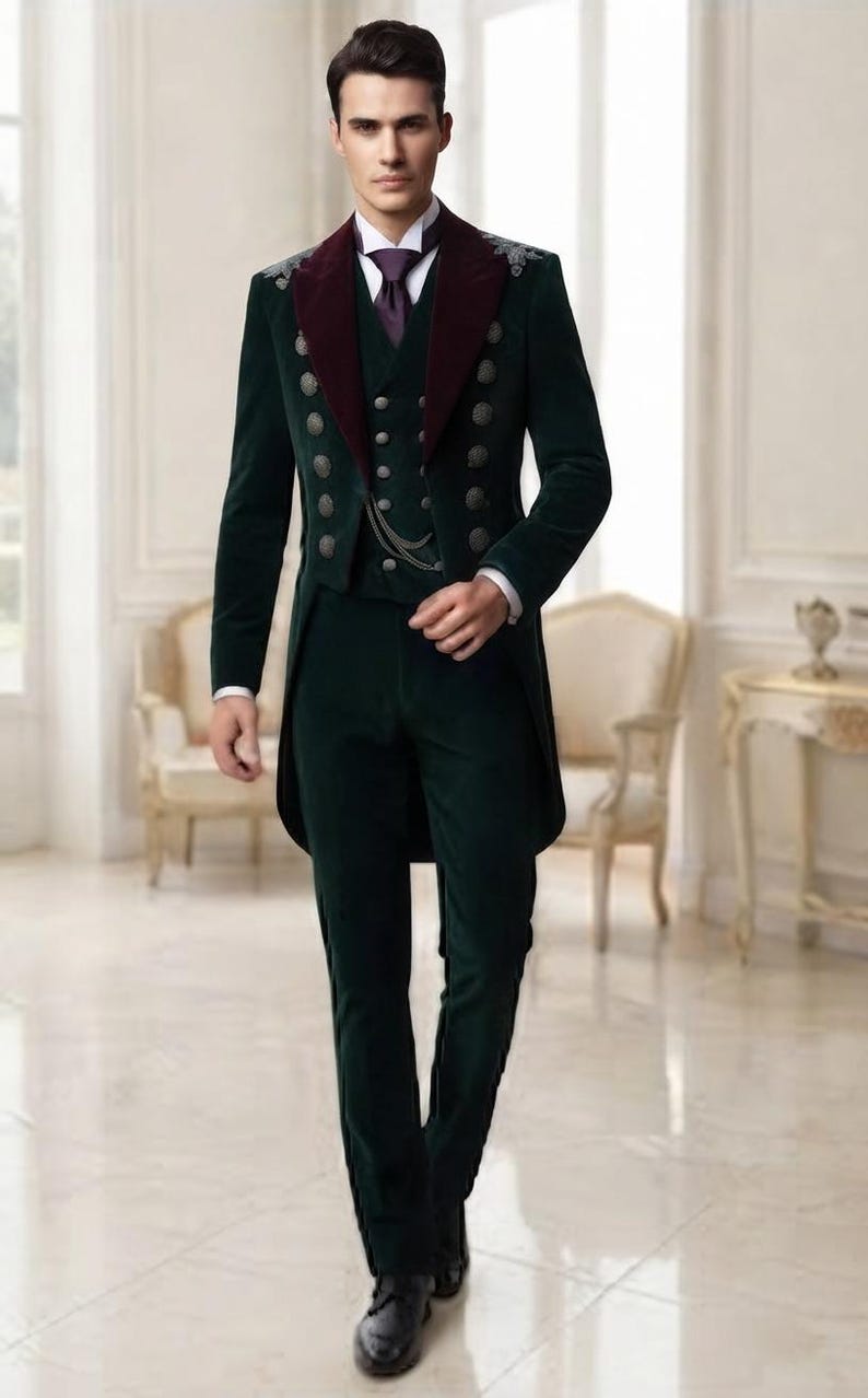 May include: A dark green velvet tailcoat suit featuring a deep burgundy lapel, a matching waistcoat with two columns of silver buttons, a white collared shirt, and a purple necktie. The jacket includes silver shoulder embroidery and a chain detail.