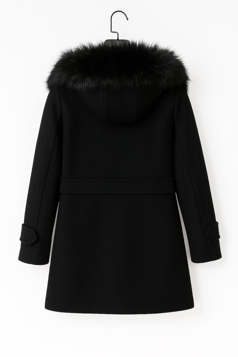 May include: A black winter coat with a hood trimmed with dark faux fur. The coat features a belt detail at the waist, and buttoned cuffs. The coat is designed for warmth and style.