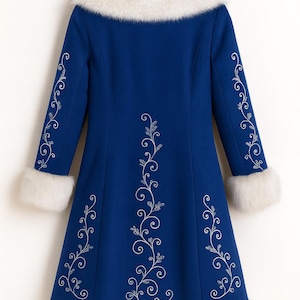 May include: A royal blue coat featuring a white faux fur collar, cuffs, and hem. The coat is decorated with silver-toned floral embroidery patterns running vertically along the center back and down the length of each sleeve.
