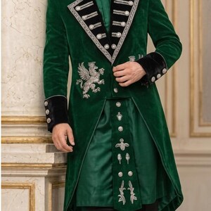May include: A dark green velvet long coat featuring black velvet lapels and cuffs, silver embroidery, and metallic buttons. The coat displays a prominent silver griffin emblem on the chest, paired with a matching green tunic and black trousers.