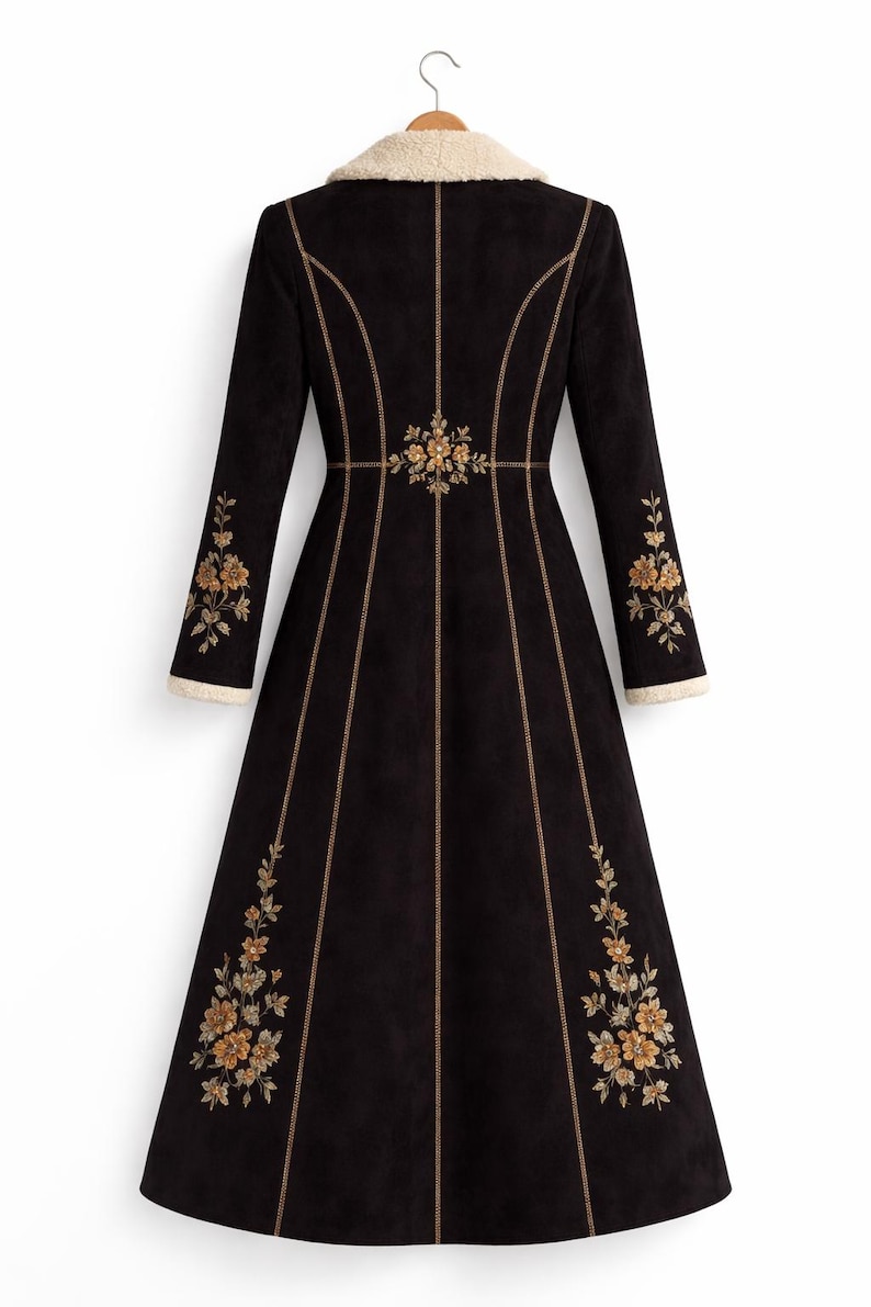 May include: A long black coat featuring a cream-coloured faux shearling collar and sleeve cuffs. The coat is decorated with gold-toned floral embroidery on the sleeves and lower panels, with vertical gold-toned piping along the seams.