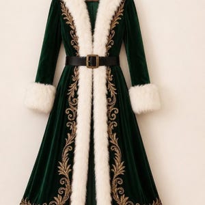 May include: A long, dark green velvet coat featuring a white faux fur collar and cuffs, adorned with intricate gold embroidery along the front panels. The coat is cinched at the waist with a black belt that has a rectangular gold-toned buckle.