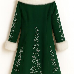 Pu&ograve; includere: Un cappotto verde bosco con colletto, polsini e orlo in pelliccia sintetica bianca. Il cappotto &egrave; decorato con motivi a spirale ricamati in argento lungo le maniche e sul pannello centrale posteriore del capo di abbigliamento.